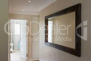 Wooden framed mirror on white wall