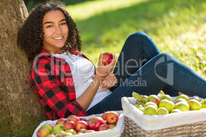 Mixed Race African American Girl Teenager Eating Apple by Tree