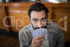 Smiling man holding cards in bar