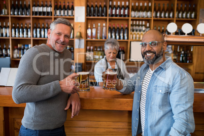 Two men having glass of bear at counter in restaurant