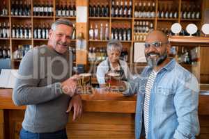 Two men having glass of bear at counter in restaurant