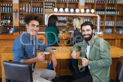 Two friends having glass of beer in bar