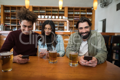 Friends using mobile phone on table