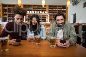 Friends using mobile phone on table