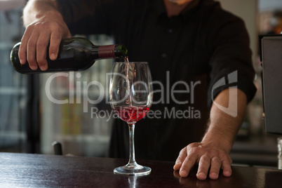 Waiter pouring wine in the glass