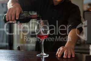 Waiter pouring wine in the glass