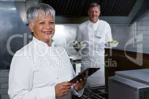 Female chef holding digital tablet
