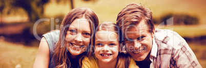 Portrait of parents with daughter lying in park