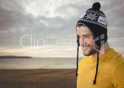 Man with warm hat by sea field