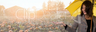 Woman in Autumn with apple in bright pumpkin field