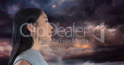 Woman looking forward with mystical dark clouds background