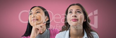 Two women looking up with pink background