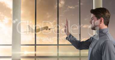 Businessman waving goodbye to plane out window