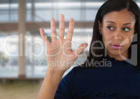 Businesswoman opening hand in front of windows in large hall