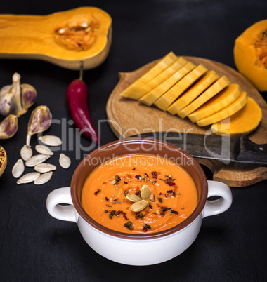 pumpkin soup in a ceramic plate and pieces of pumpkin