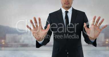 Businessman touching air with open hands in front of city