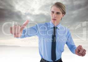 Businessman touching air in front of clouds