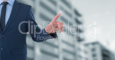 Businessman touching air in front of buildings