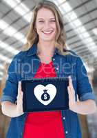 Woman holding tablet with money bag icon and heart icon