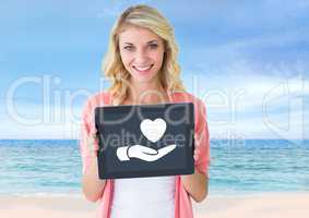 Woman holding tablet with hand giving heart icon