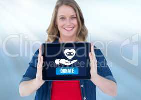 Woman holding tablet with donate button and hand giving money with love icon to charity