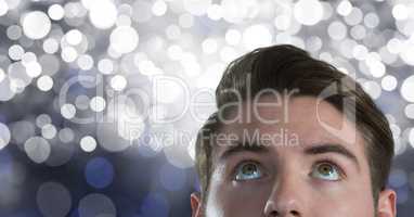 Man looking up with sparkling background