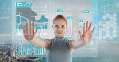 Data charts interface and Futuristic Businesswoman touching air in front of grey grunge city