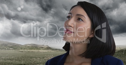 Woman looking up with cloudy landscape background
