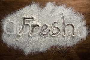 The word fresh written on sprinkled flour