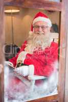 Portrait of santa claus reading novel during christmas time
