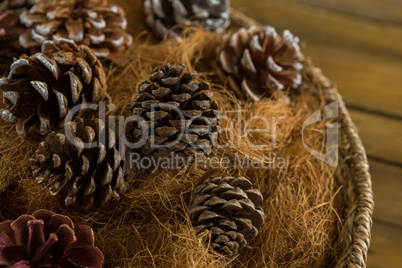 Close up of pine cones and hay in basket