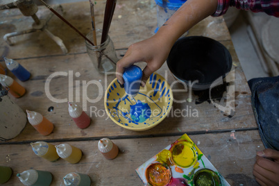 Girl decorating bowl with paint