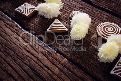 Various christmas cookies and decorations arranged on wooden plank