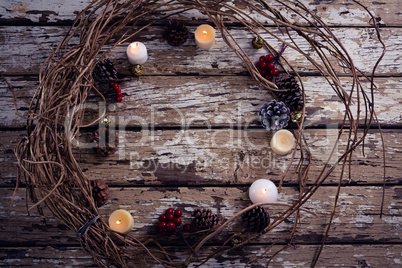 Lit candles and christmas decoration on wooden plank