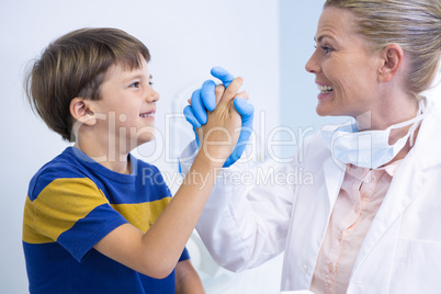 Smiling dentist playing with boy