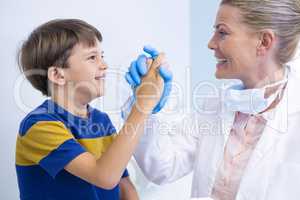 Smiling dentist playing with boy