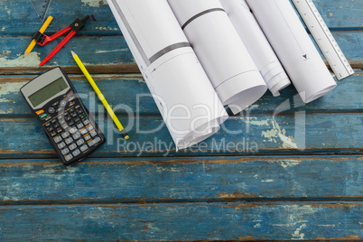 Rolled-up documents and stationary on wooden plank