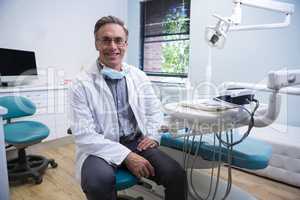 Portrait of smiling dentist sitting on chair