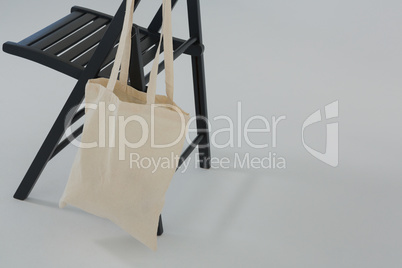 Beige bag hanging on a black chair