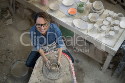 Overhead of female potter molding a clay
