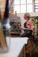 Woman painting on canvas