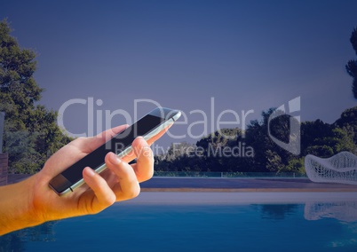 Hand holding phone at home swimming pool