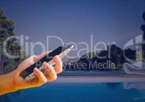 Hand holding phone at home swimming pool