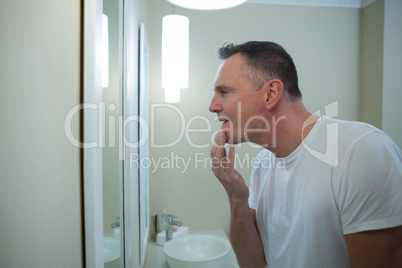 Man looking his face in the mirror after shaving