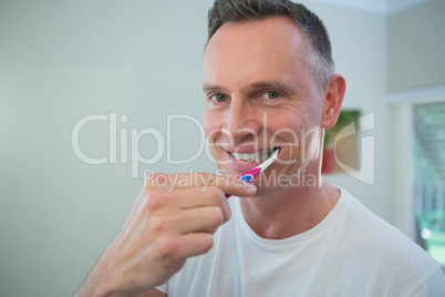 Man brushing his teeth with toothbrush