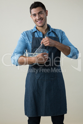 Chef holding a whisk in the bowl
