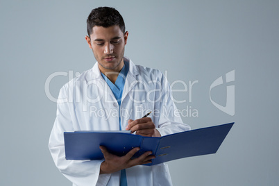 Doctor writing a reports in the file