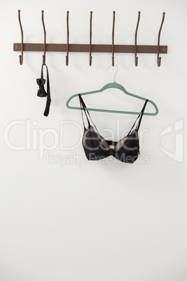 Lingerie and bow tie hanging on hook