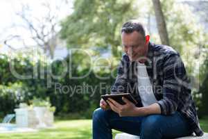 Man using digital tablet in garden