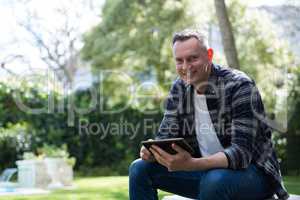 Man using digital tablet in garden